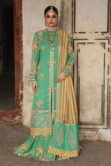 Woman wearing a traditional green and gold outfit with embroidery, standing against a plain background.