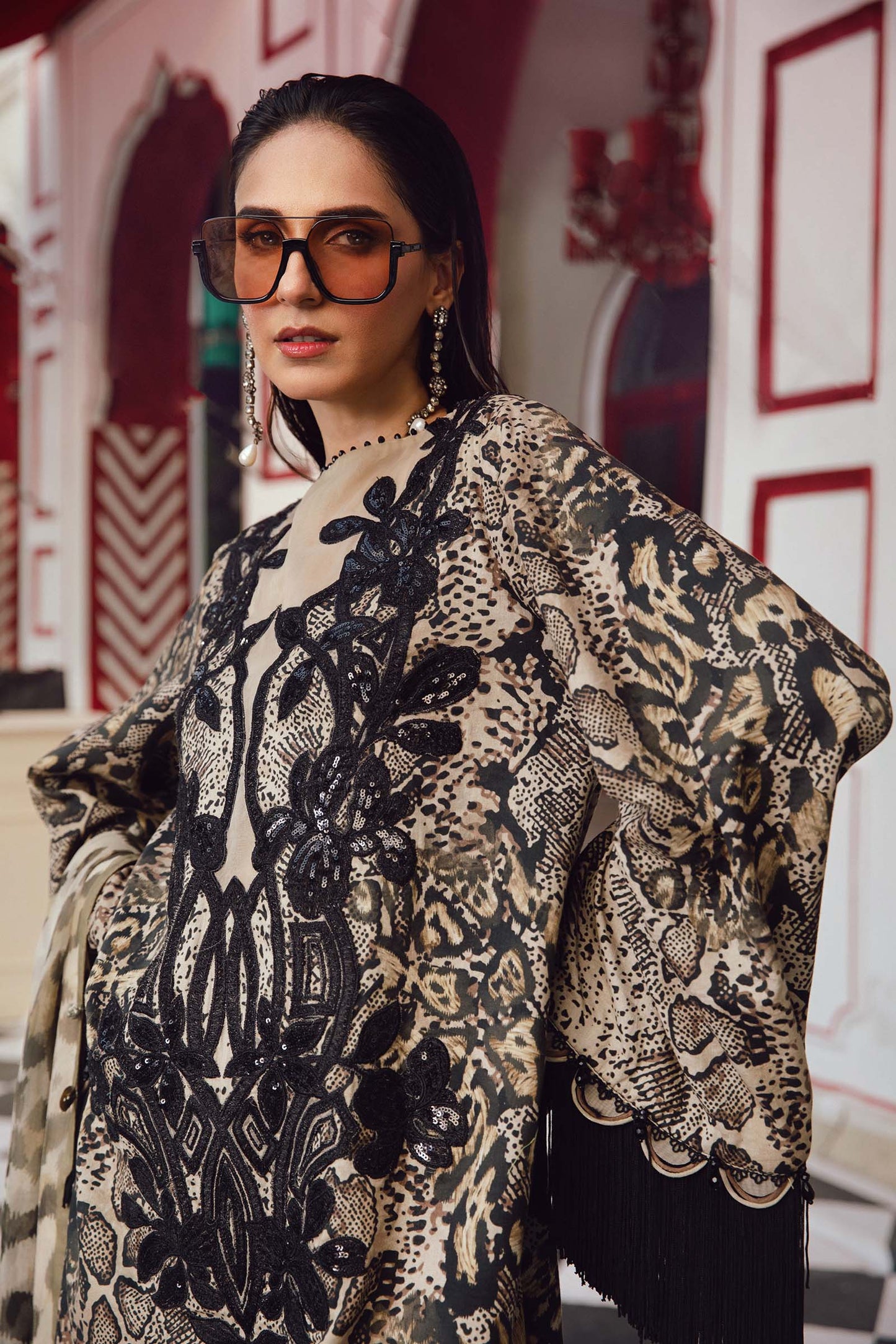 Woman wearing a patterned outfit with sunglasses in an indoor setting