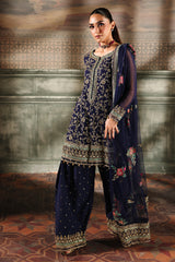 Woman wearing a traditional outfit with intricate patterns in a decorative setting