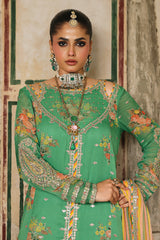 Woman wearing a green traditional outfit with intricate patterns and jewelry.
