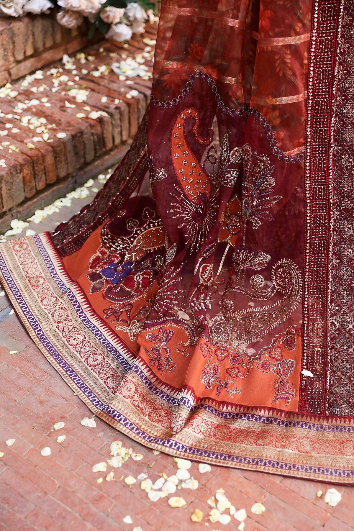 Close-up of a traditional embroidered fabric with intricate patterns on a brick surface.