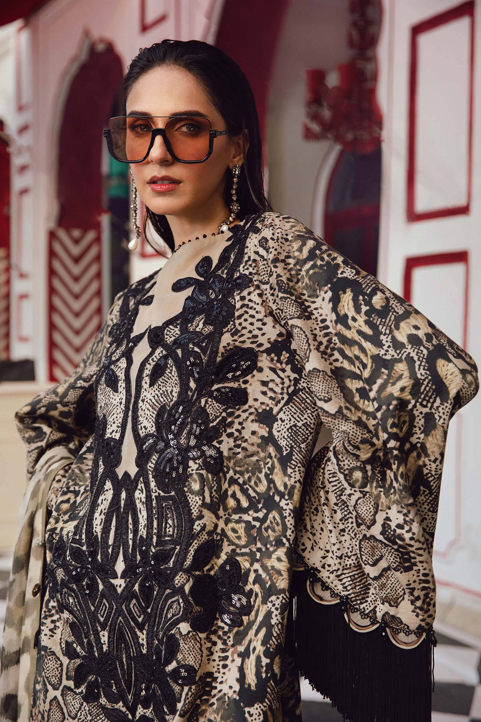 Woman wearing a patterned outfit with sunglasses in an indoor setting