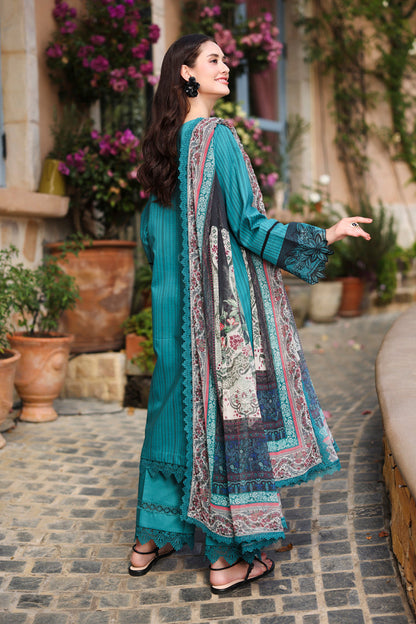 Woman in a teal traditional outfit with a patterned dupatta standing outdoors.
